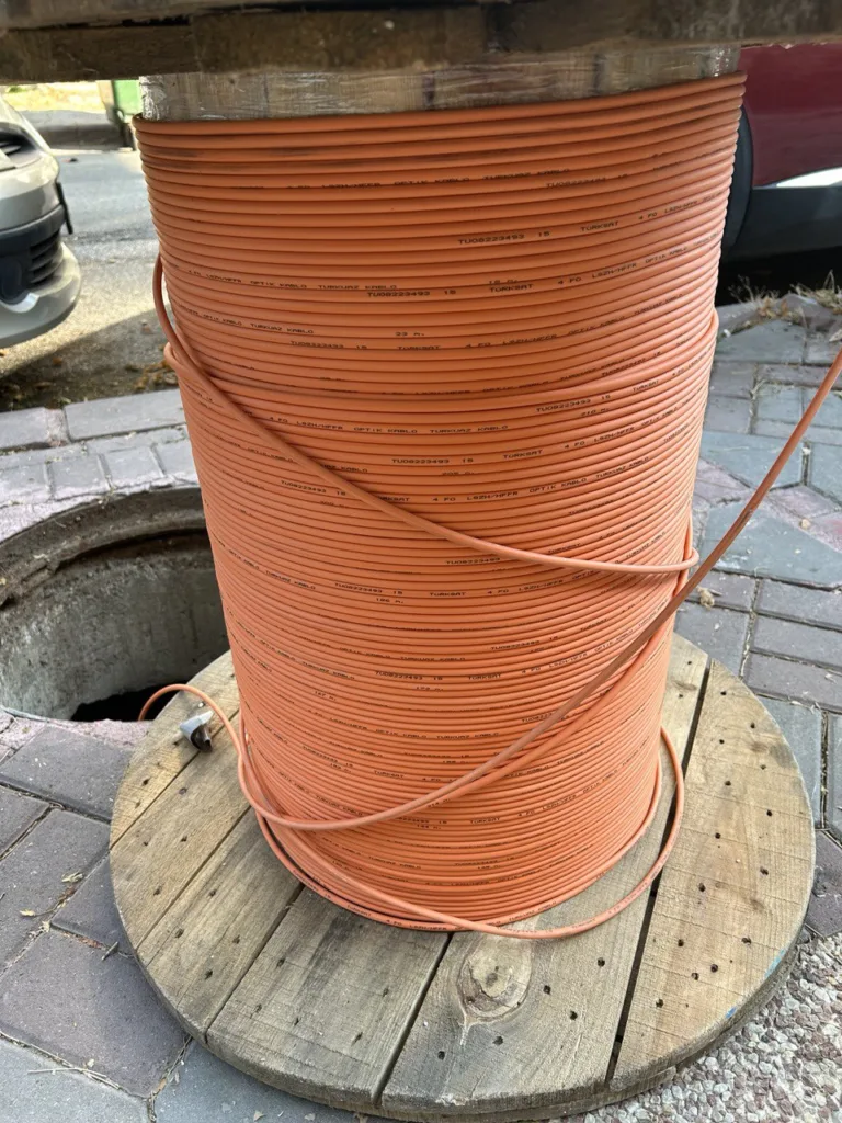 Turuncu fiber optik kablo rulosu, manhole kenarı.